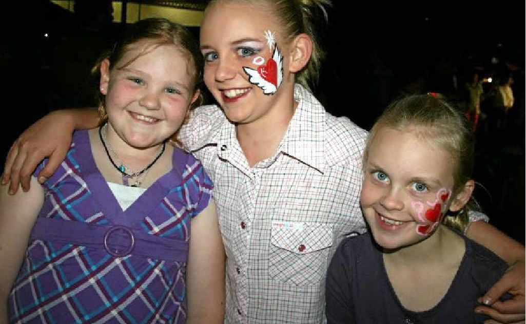 Emily Guy and Alexis and Hayley Carey hug it out at the Mardi Gras last year. 